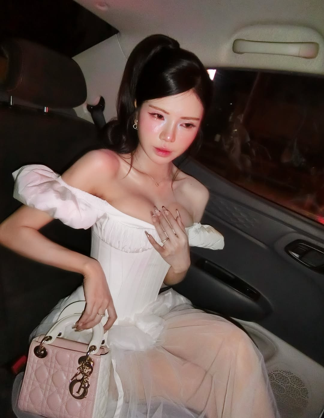 Điểm nhấn của tổng thể nằm ở phần cổ áo trễ vai và thiết kế corset nhẹ, vừa mang hơi hướng cổ điển, vừa tạo hiệu ứng thị giác nổi bật.