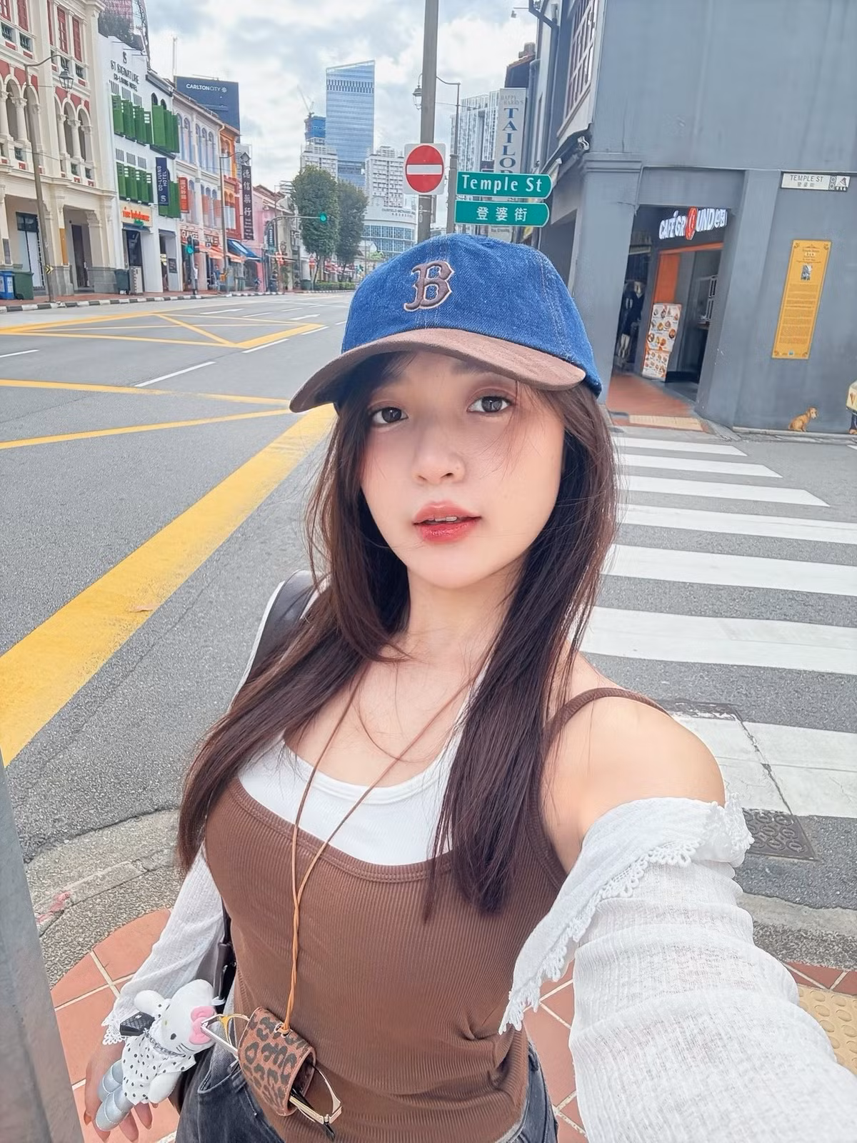 Trong những khoảnh khắc được chia sẻ, Phương Thảo lựa chọn phong cách ăn mặc trẻ trung, năng động với áo hai dây phối cùng áo khoác mỏng và mũ lưỡi trai. Set đồ đơn giản giúp tôn lên vẻ ngoài nhẹ nhàng, gần gũi, đúng tinh thần của những bức ảnh street style đời thường.