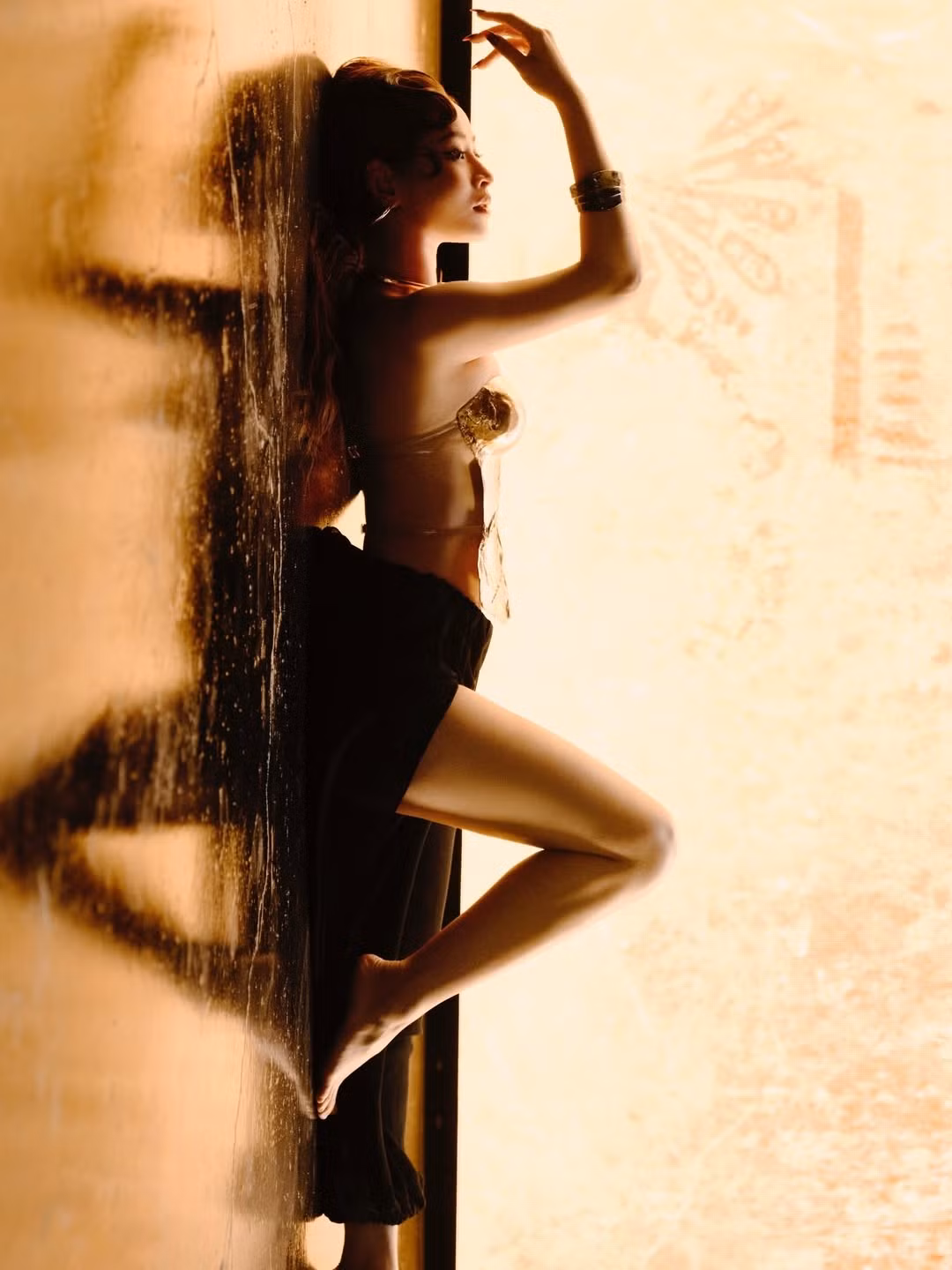 Trong bộ ảnh, Chi Pu diện thiết kế corset ánh kim với tạo hình như được đúc từ kim loại nóng chảy. Chất liệu nhũ vàng phản chiếu ánh sáng giúp tôn trọn bờ vai thon, vòng eo nhỏ và khuôn ngực quyến rũ. Đây là phong cách mang hơi hướng “nữ thần chiến binh”, vừa mềm mại vừa mạnh mẽ.