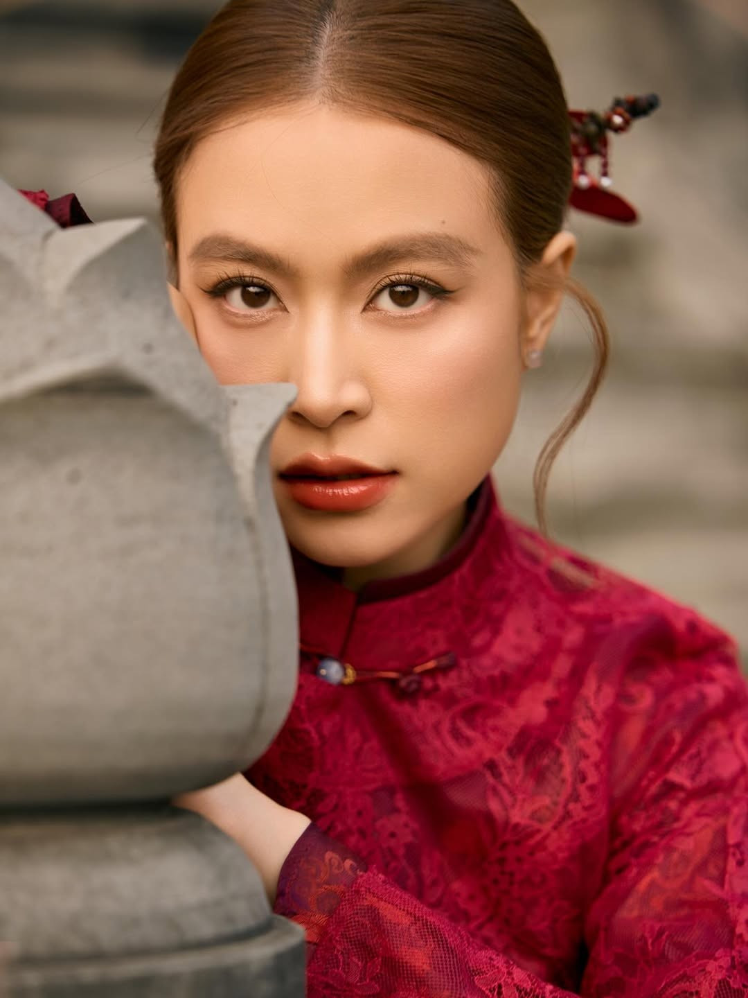 Trong bộ ảnh được đăng tải, Hoàng Thùy Linh xuất hiện trong thiết kế áo dài màu đỏ trầm, mang phom dáng truyền thống kết hợp chất liệu ren tinh tế. Gam màu đỏ – biểu tượng của may mắn, hạnh phúc và khởi đầu mới – càng làm nổi bật vẻ đẹp nền nã, đằm thắm của nữ ca sĩ trong dịp đầu xuân.