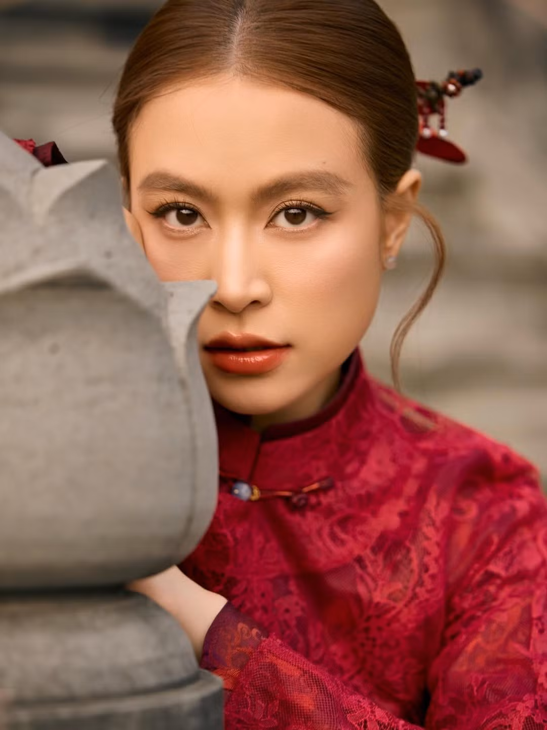 Trong bộ ảnh được đăng tải, Hoàng Thùy Linh xuất hiện trong thiết kế áo dài màu đỏ trầm, mang phom dáng truyền thống kết hợp chất liệu ren tinh tế. Gam màu đỏ – biểu tượng của may mắn, hạnh phúc và khởi đầu mới – càng làm nổi bật vẻ đẹp nền nã, đằm thắm của nữ ca sĩ trong dịp đầu xuân.