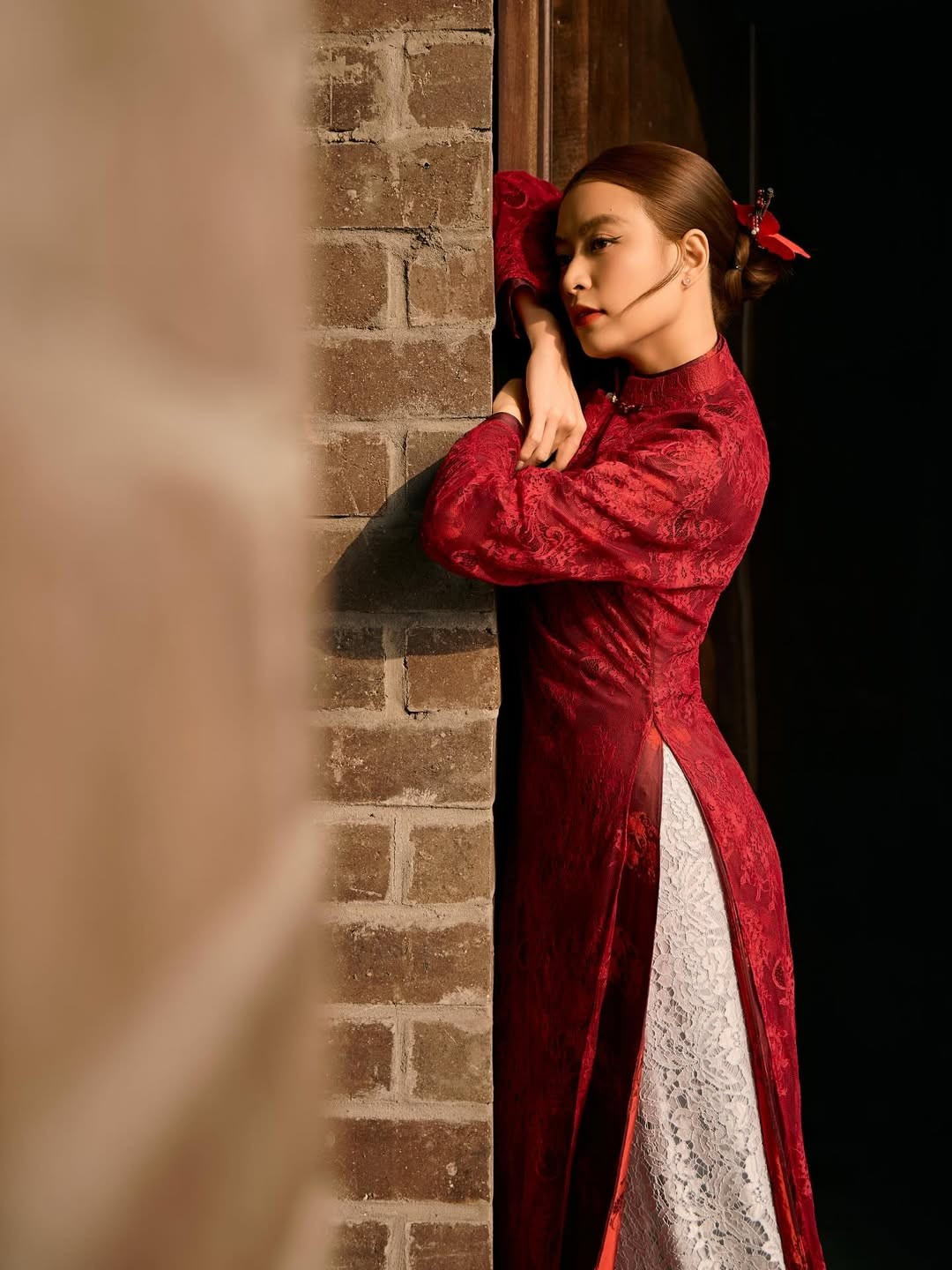 Bối cảnh bộ ảnh của Hoàng Thùy Linh cũng góp phần tạo nên sức hút đặc biệt. Những bậc thềm đá, tường gạch cổ và kiến trúc đậm dấu ấn truyền thống mang lại cảm giác trầm mặc, cổ kính, hòa quyện cùng tà áo dài thướt tha.