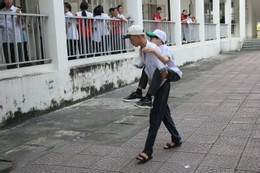 Trung Dũng cõng Tuấn Anh vào phòng thi tại điểm thi Trường THPT Chuyên Hạ Long. Ảnh: Minh Hà