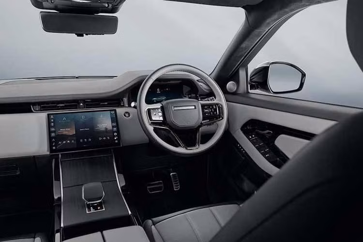Bước vào khoang nội thất, Range Rover Evoque 2026 tiếp tục theo đuổi triết lý thiết kế tối giản nhưng sang trọng. Điểm nhấn là màn hình cảm ứng kính cong 11,4 inch đặt nổi trên bảng táp-lô, vận hành trên hệ thống thông tin giải trí Pivi Pro. Toàn bộ các chức năng chính của xe được tích hợp trên màn hình này.