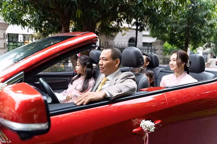 Trong khi đó, dẫn đầu đoàn đón dâu là chiếc VinFast VF8 mui trần sơn màu đỏ rực rỡ. Đích thân Chủ tịch Vingroup Phạm Nhật Vượng đã cầm lái chiếc VF8 chế tác riêng này để chở con, cháu tới xin dâu.