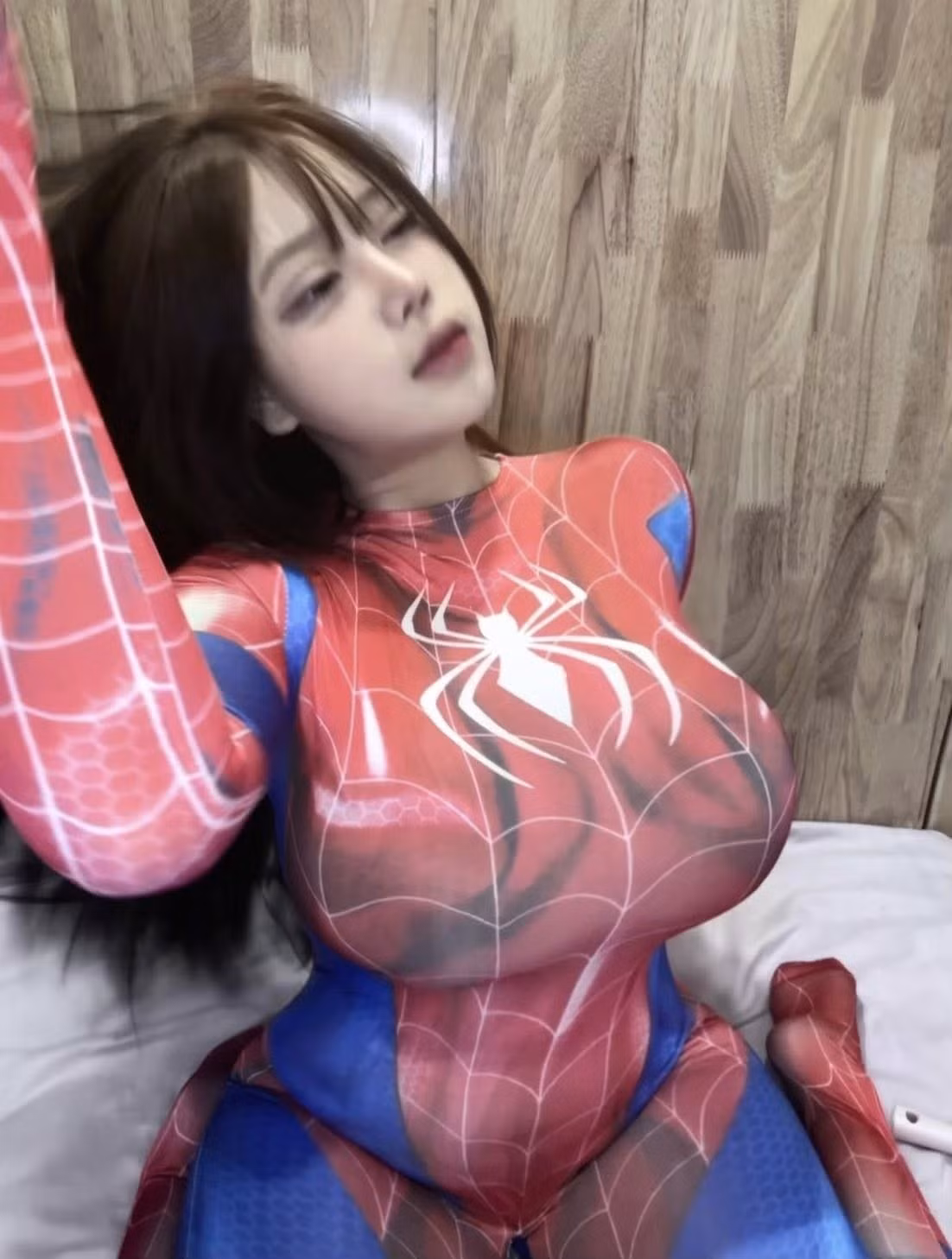 Kiểu tóc dài thẳng kết hợp mái thưa nhẹ tạo cảm giác mềm mại, tương phản thú vị với sự mạnh mẽ của bộ suit siêu anh hùng.