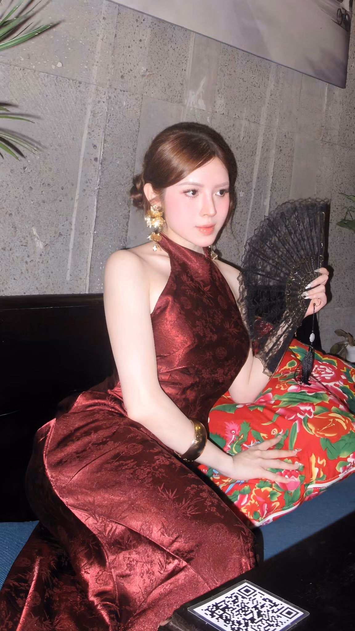 Khoác lên mình thiết kế sườn xám gam đỏ rượu trầm sang trọng, cựu người đẹp hàng không Phan Quế Chi khoe trọn bờ vai mảnh mai cùng làn da trắng mịn, tạo nên tổng thể vừa cổ điển, vừa quyến rũ.