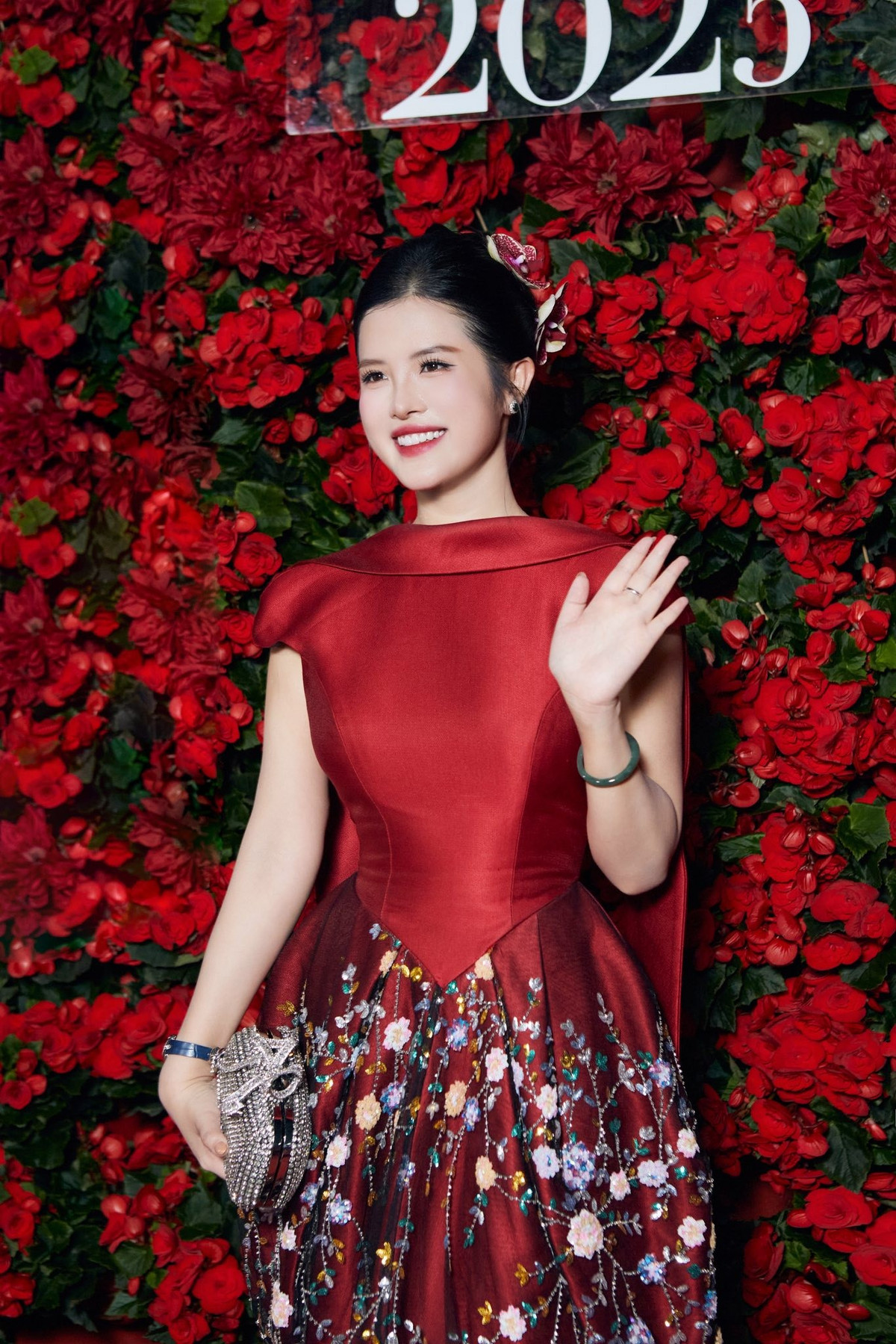 Khác hẳn vẻ chỉn chu, nghiêm túc trong các bản tin, BTV VTV là Hải Vân gây bất ngờ khi khoe sắc trong thiết kế mang tông đỏ chủ đạo nổi bật giữa không gian ngập tràn hoa rực rỡ.