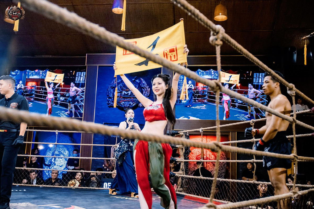 Mới đây, Kiều Oanh lại gây bất ngờ khi xuất hiện với một hình tượng hoàn toàn khác – nàng thơ dịu dàng, duyên dáng trong tà áo yếm cầm biển trên sàn đấu võ MMA.