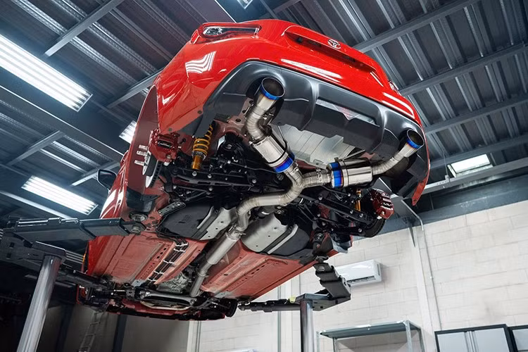 Tiếp đến là bộ phuộc Ohlins Road &amp; Track và sau cùng là dàn pháo Tomei từ chất liệu titanium (bao gồm cả header titan) giúp chiếc xe có tiếng thở ấn tượng hơn mỗi khi tăng tốc. Ở khoang máy, bộ ốp máy carbon của hãng Armaspeed cũng được thêm vào.