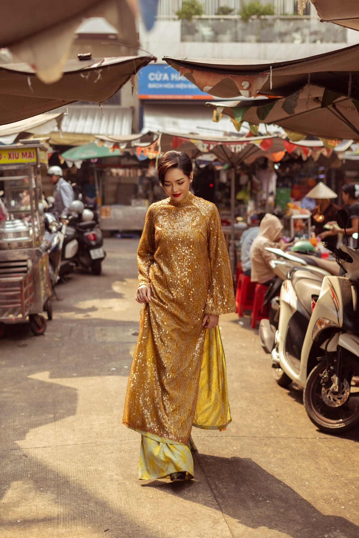 Người đẹp xuất hiện trước những bức tường chạm khắc họa tiết cổ, cổng chùa, lồng đèn đỏ và các cửa tiệm lâu năm mang đậm phong vị Hoa. Sự đối lập thú vị giữa tà áo dài Việt Nam và không gian kiến trúc đậm chất Trung Hoa tạo nên cảm giác giao thoa văn hóa đầy nghệ thuật.