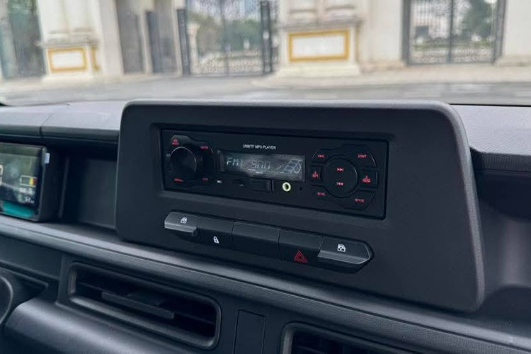 Khác với hình ảnh mô phỏng, cửa xe không còn tay quay hạ kính mà chuyển sang loại chỉnh điện, vận hành qua cụm nút gạt đặt dưới vị trí đầu radio. Vô-lăng mang phong cách của VF3 và đi kèm cần chuyển số đặt phía sau.