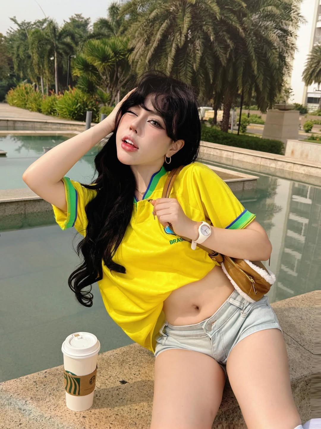 Trong những khung hình được chia sẻ, Bảo Khuyên Susan chọn áo bóng đá sắc vàng nổi bật, dáng croptop ôm gọn phần eo, kết hợp quần short cạp thấp và tất cao cổ, tạo tổng thể khỏe khoắn nhưng vẫn gợi cảm vừa đủ.