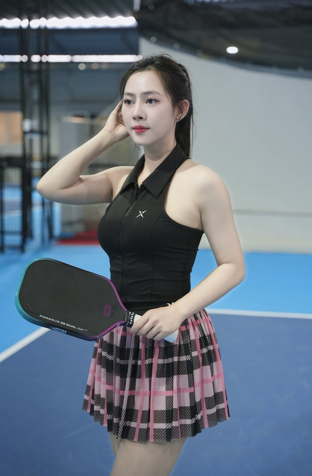 Chiếc áo sát nách kết hợp chân váy ngắn xếp ly giúp cô khoe bờ vai thon gọn, vòng eo săn chắc và đôi chân dài nuột nà.