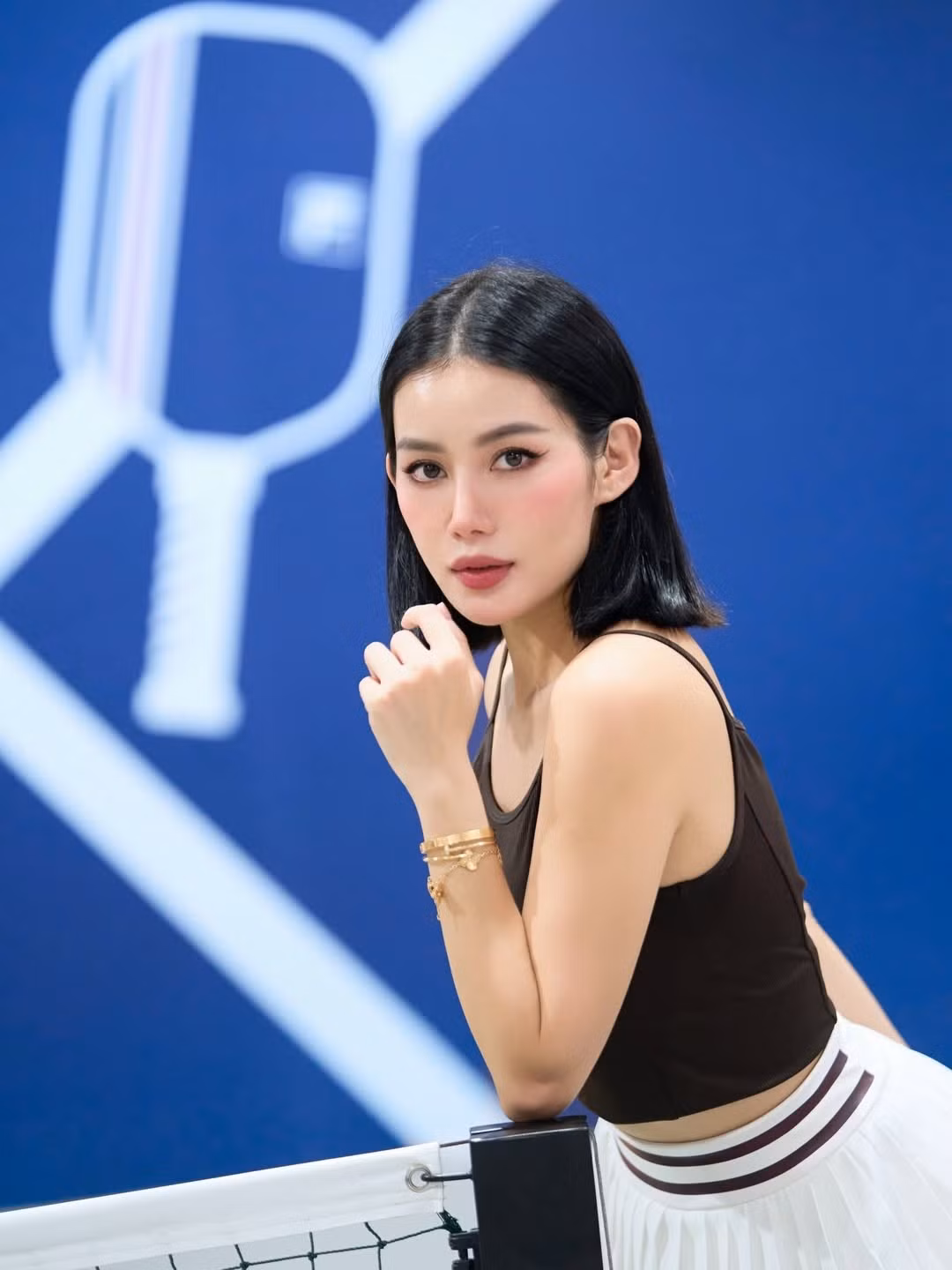 Trong những hình ảnh được ghi lại, Milan Phạm diện áo hai dây ôm sát tôn lên vai thon và vòng eo gọn gàng, kết hợp với chân váy tennis xếp ly trắng trẻ trung.