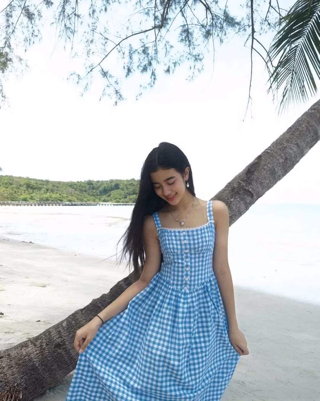 Trong chuyến nghỉ dưỡng tại khu resort Mafiya's, cô chọn đầm maxi họa tiết gingham theo phong cách đồng quê phối trang sức ngọc trai.