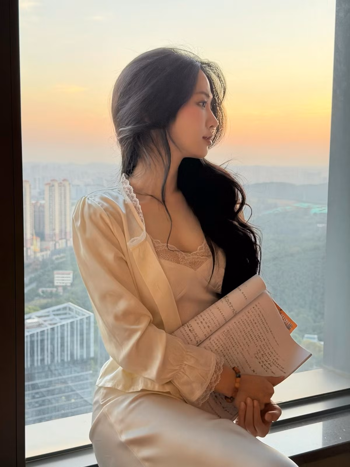 Đặc biệt, khi cô ngồi bên cửa kính với bó hoa rực rỡ hoặc cầm những trang tài liệu, cả khung hình toát lên cảm giác điện ảnh — như cảnh quay của một bộ phim lãng mạn. Không gian thành phố phía sau mờ ảo càng làm nổi bật vẻ đẹp của Lê Bống theo phong cách “nàng thơ thời hiện đại”.