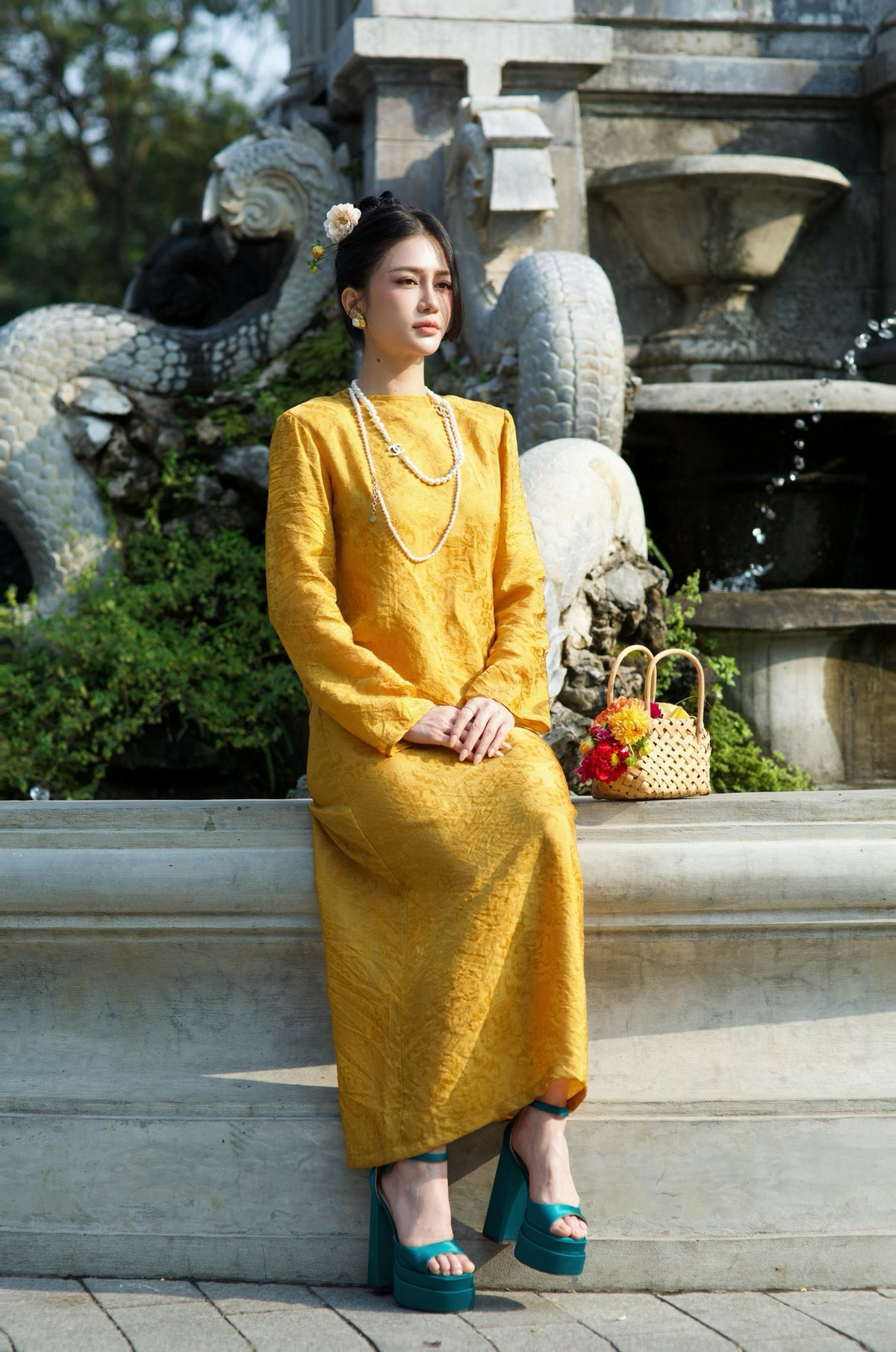 Phom dáng áo dài truyền thống được xử lý tinh tế, giúp tổng thể của người đẹp Quảng Ninh trở nên mềm mại và sang trọng. Phụ kiện ngọc trai phối cùng giày cao gót tông xanh tạo điểm nhấn thời thượng nhưng không phá vỡ tinh thần thuần Việt của trang phục.