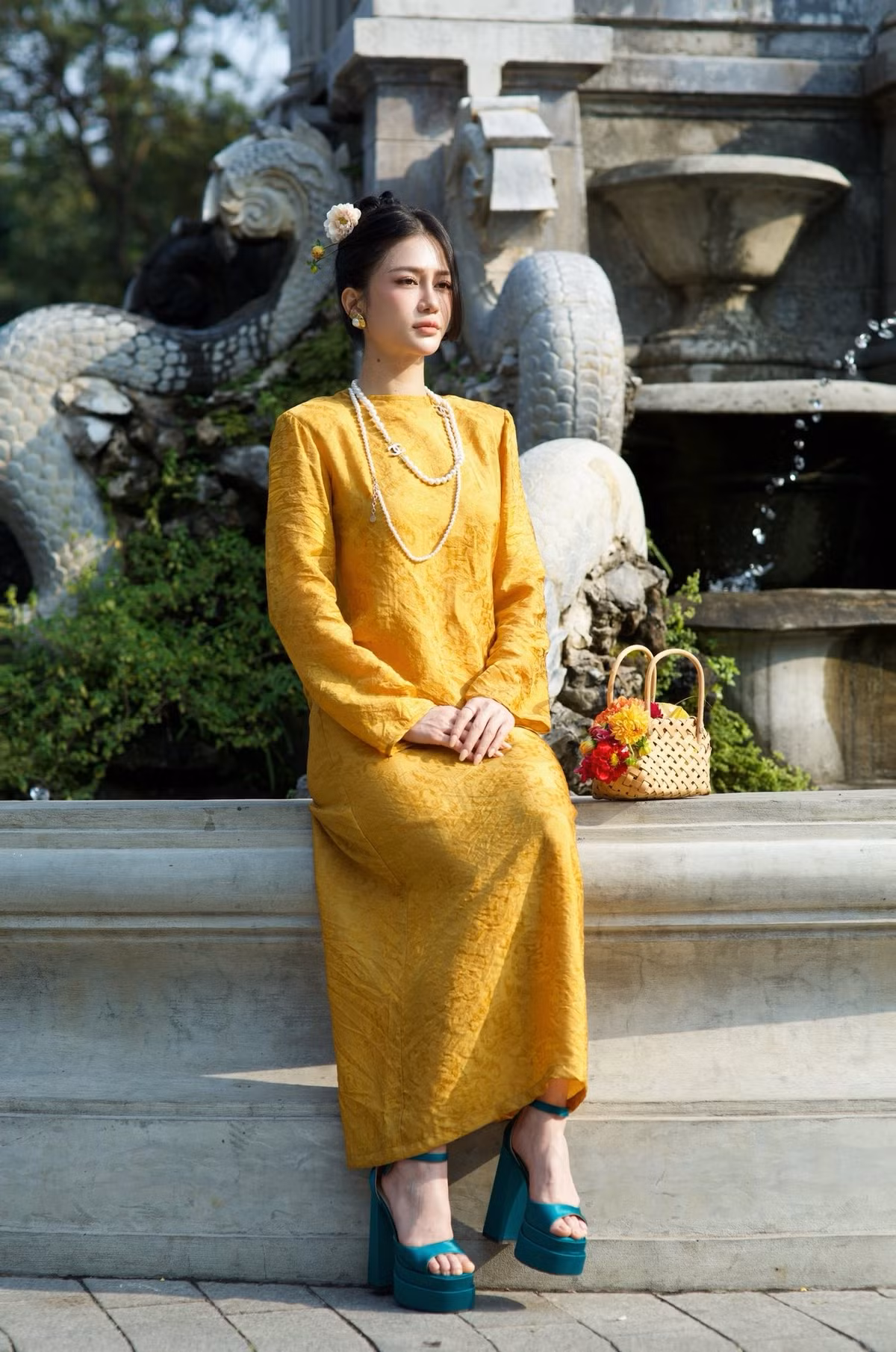 Phom dáng áo dài truyền thống được xử lý tinh tế, giúp tổng thể của người đẹp Quảng Ninh trở nên mềm mại và sang trọng. Phụ kiện ngọc trai phối cùng giày cao gót tông xanh tạo điểm nhấn thời thượng nhưng không phá vỡ tinh thần thuần Việt của trang phục.