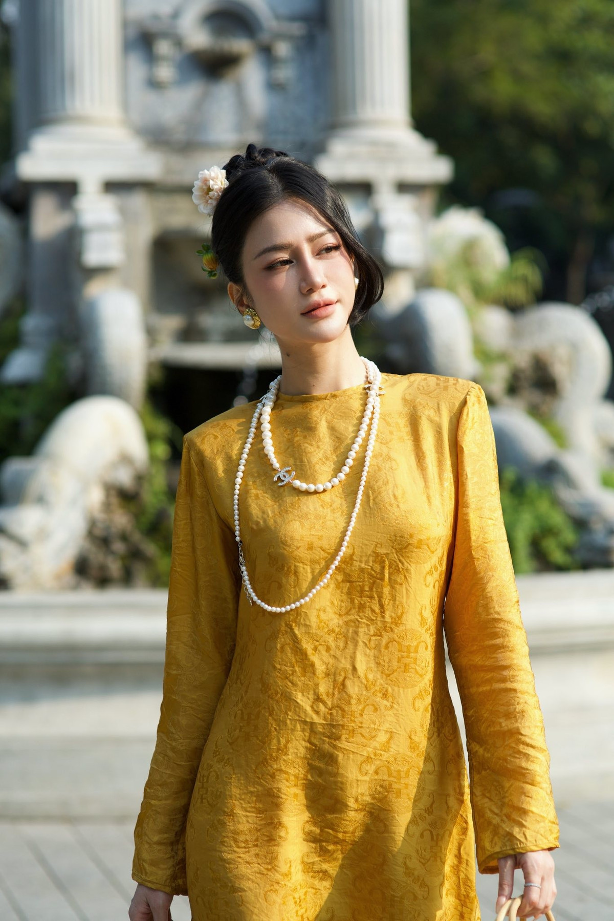 Kiểu tóc vấn thấp cài hoa nhỏ cùng lớp trang điểm trong trẻo càng làm nổi bật khí chất nền nã. Ở mỗi khung hình, người đẹp sinh năm 1994 toát lên thần thái tự tin, chững chạc—một vẻ đẹp trưởng thành, kín đáo nhưng cuốn hút.