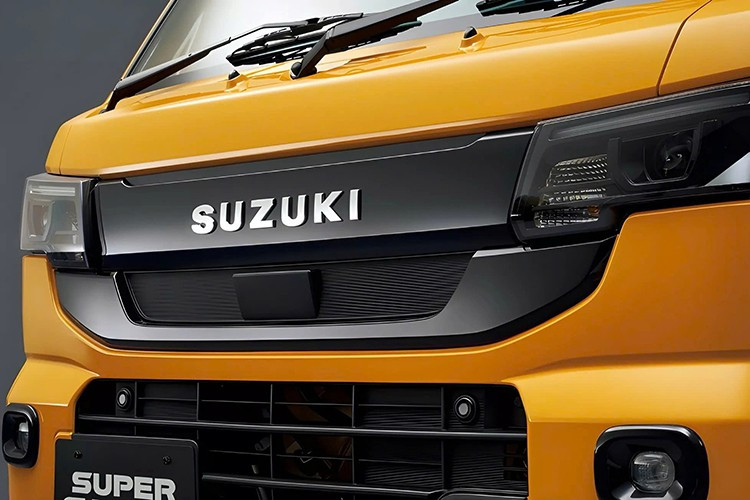 Thay đổi lớn nhất của Suzuki Carry 2026 về mặt ngoại hình nằm ở phía trước, nơi phần mũi xe được thiết kế lại với đèn pha bố trí nằm ngang. Đèn pha mới kết hợp với lưới tản nhiệt mỏng hơn và hốc hút gió trên cản trước lớn hơn.