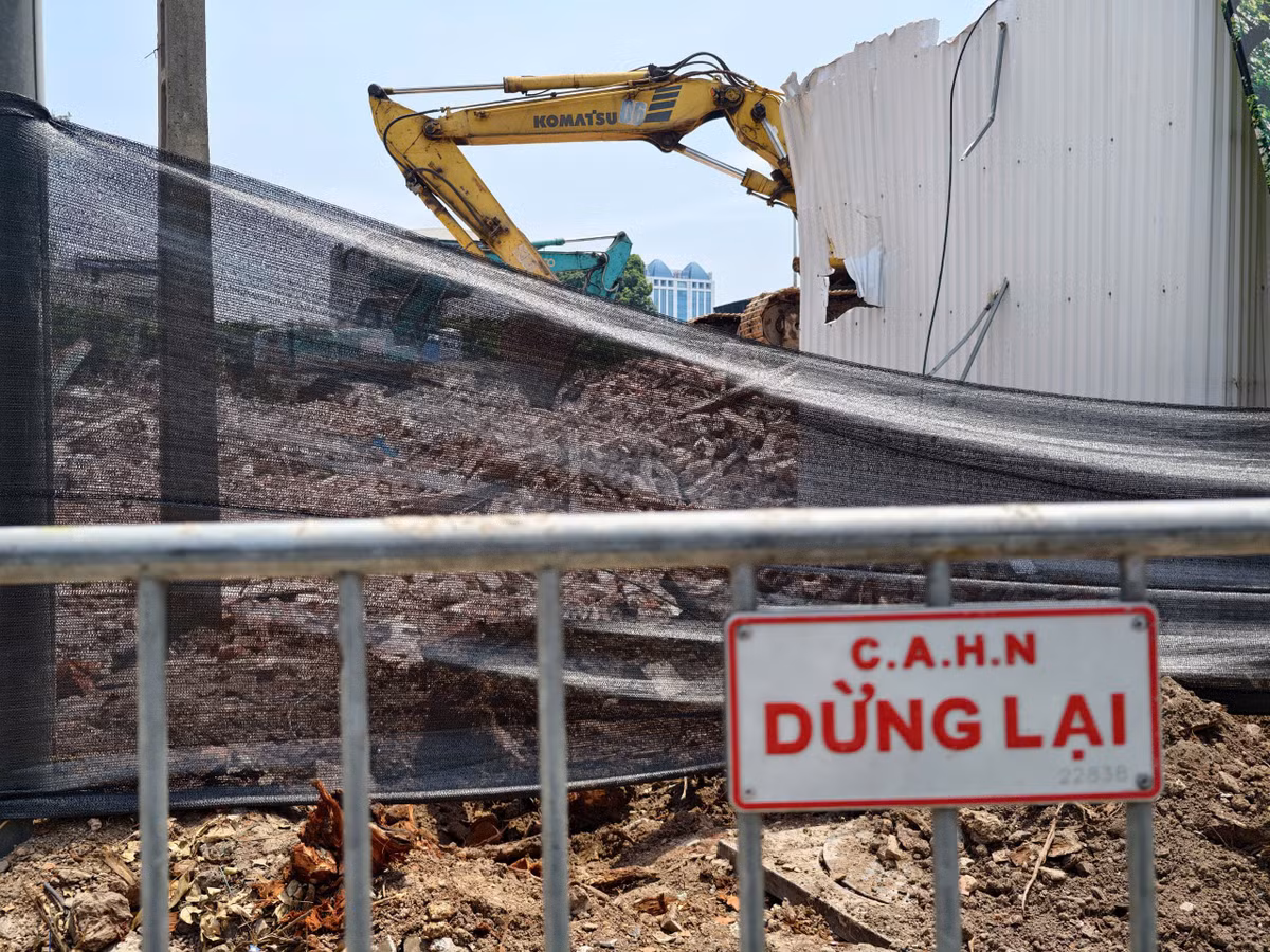 Các công nhân cùng máy cẩu, máy khoan, cắt sắt đang gấp rút phá dỡ tòa nhà.