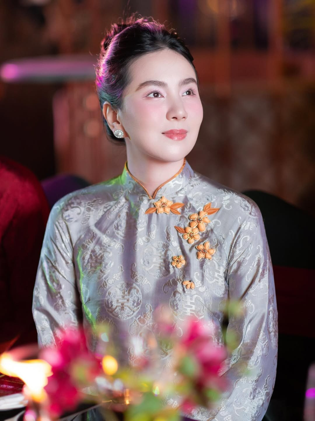 Thiết kế áo dài mà Mai Ngọc diện mang gam màu trung tính nhã nhặn, sử dụng chất liệu gấm cao cấp với họa tiết cổ điển dệt chìm. Phom dáng áo dài chuẩn mực, kín đáo nhưng vẫn khéo léo tôn lên vóc dáng thanh thoát của người mặc.