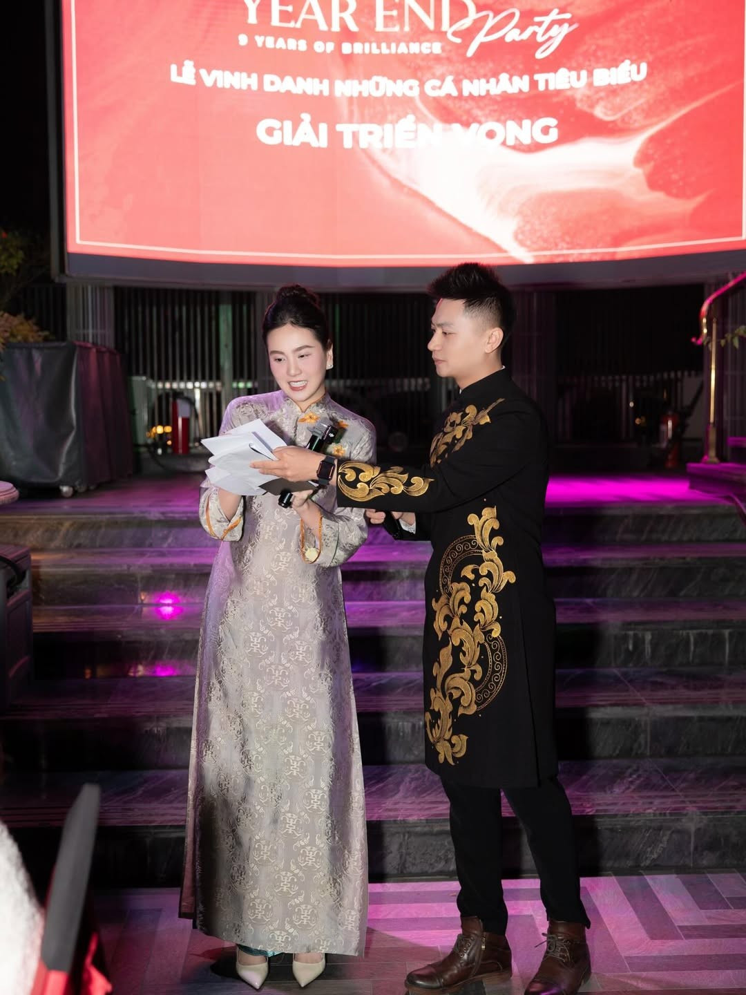 Trong không gian sự kiện được dàn dựng trang trọng, ánh sáng sân khấu kết hợp cùng sắc áo dài càng làm nổi bật thần thái của MC Mai Ngọc.