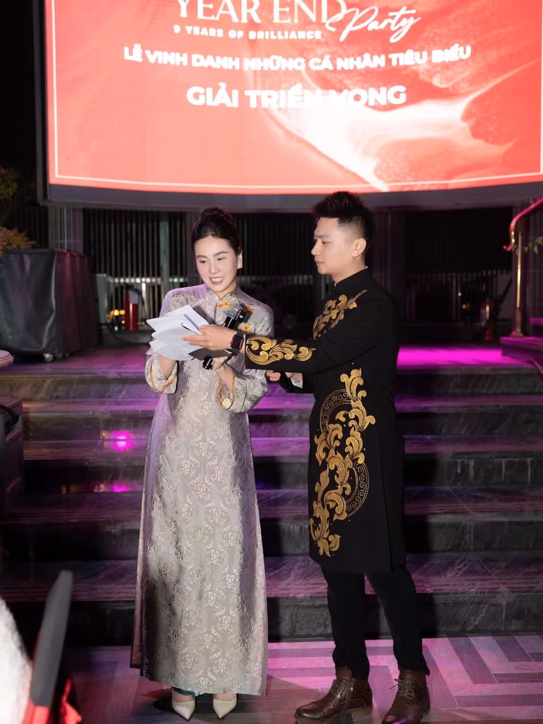 Trong không gian sự kiện được dàn dựng trang trọng, ánh sáng sân khấu kết hợp cùng sắc áo dài càng làm nổi bật thần thái của MC Mai Ngọc.