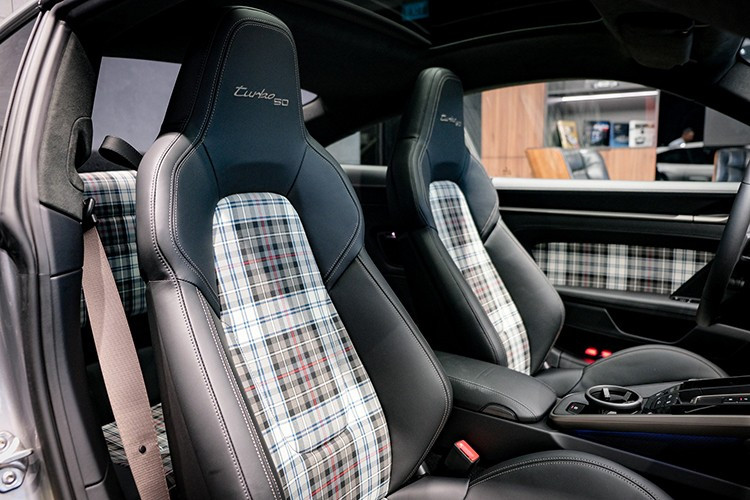 Bề mặt tapi cửa, tựa lưng hàng ghế sau cũng được bọc chất liệu vải dệt Tartan. Phong cách cổ điển này cũng được áp dụng trên các mẫu 911 Sport Classic hay 911 Spirit 70. Xe được trang bị tiêu chuẩn gói Sport Chrono, mang đến cho chiếc Porsche 911 Turbo 50 Years nhiều tính năng như Launch Control,...