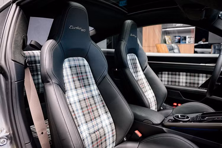 Bề mặt tapi cửa, tựa lưng hàng ghế sau cũng được bọc chất liệu vải dệt Tartan. Phong cách cổ điển này cũng được áp dụng trên các mẫu 911 Sport Classic hay 911 Spirit 70. Xe được trang bị tiêu chuẩn gói Sport Chrono, mang đến cho chiếc Porsche 911 Turbo 50 Years nhiều tính năng như Launch Control,...