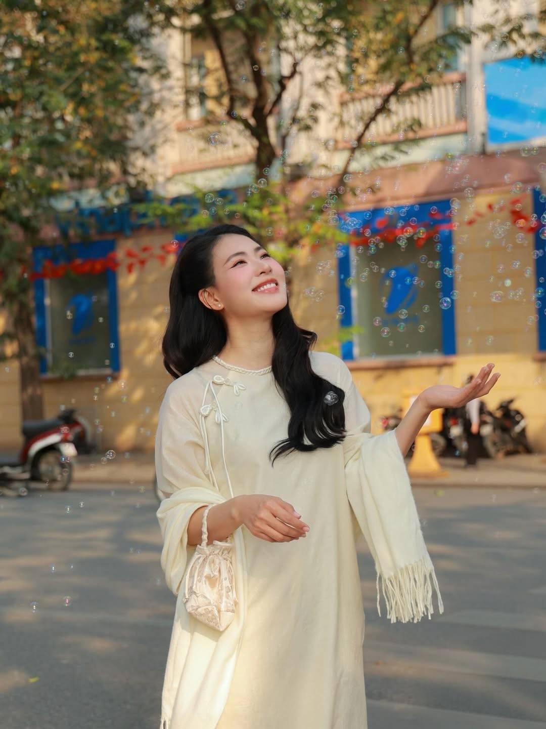 Giữa không gian Hà Nội cổ kính, Nguyễn Minh Trang lựa chọn áo dài dáng suông mềm mại, tôn lên vẻ nữ tính và thần thái an nhiên. Thiết kế tối giản, gam màu trang nhã giúp tổng thể thêm thanh thoát, hài hòa với bối cảnh Hồ Gươm nắng nhẹ.