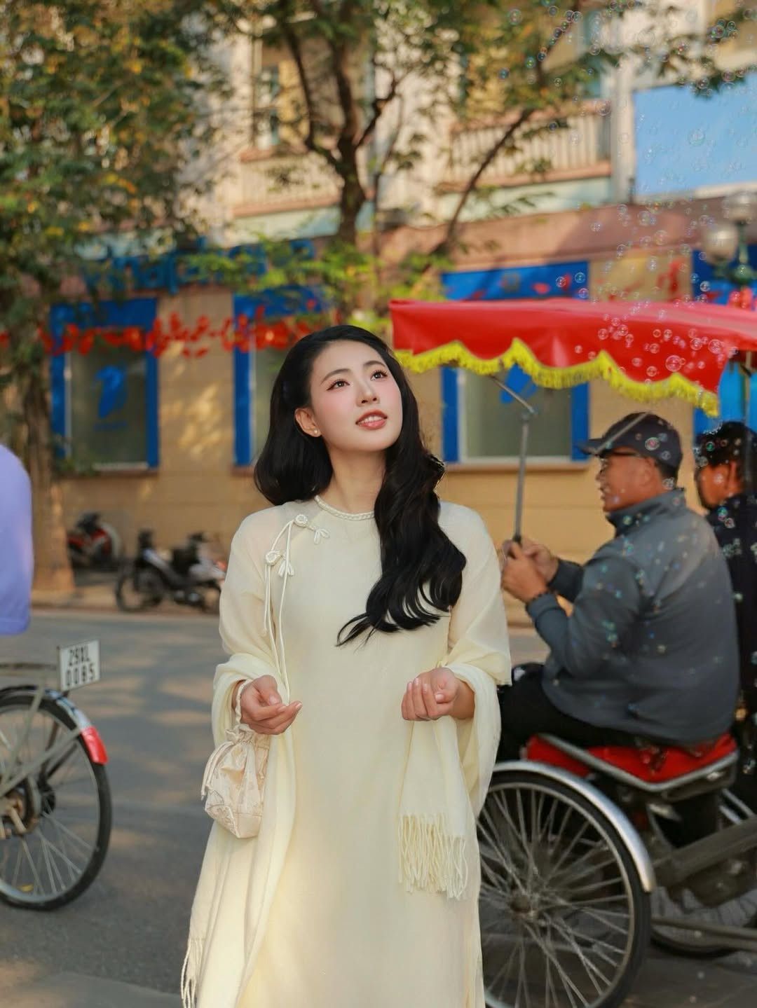 Mái tóc đen uốn sóng nhẹ buông tự nhiên càng làm nổi bật những đường nét Á Đông mềm mại, mang đến cảm giác thanh xuân rất Hà Nội.