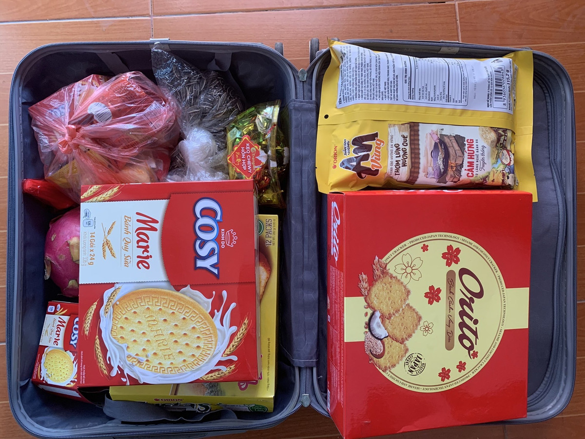 Danh sách đồ quê được mang theo vô cùng phong phú. Phổ biến nhất vẫn là bánh chưng, bánh tét còn nguyên hương vị Tết, kèm giò lụa, chả quế, thịt kho, nem rán cấp đông sẵn. Ngoài ra còn có trứng gà ta, mớ rau xanh bố mẹ vừa hái ngoài vườn, cá khô, mực khô, ruốc, lạc rang, dưa muối… Mỗi món được gói ghém cẩn thận, chia thành từng túi nhỏ, ghi chú rõ ràng để con dễ bảo quản và sử dụng.