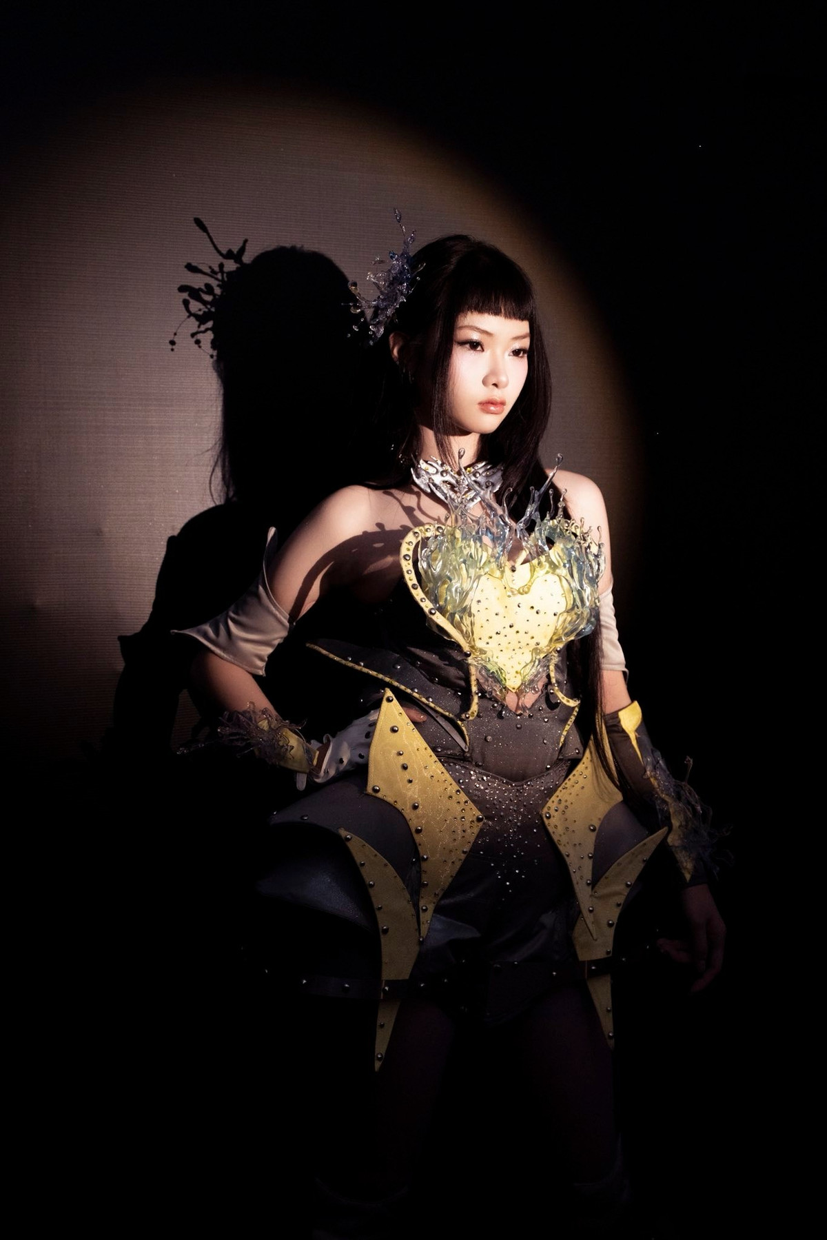 Bộ trang phục mang hơi hướng futuristic với tông xám – vàng nổi bật, phom dáng cứng cáp cùng những chi tiết tạo khối táo bạo giúp Ánh Sáng AZA toát lên khí chất mạnh mẽ, hiện đại và đầy năng lượng. Tổng thể tạo hình vừa “chất”, vừa đậm chất trình diễn, phù hợp với phong cách idol thế hệ mới mà nữ ca sĩ Gen Z đang theo đuổi.