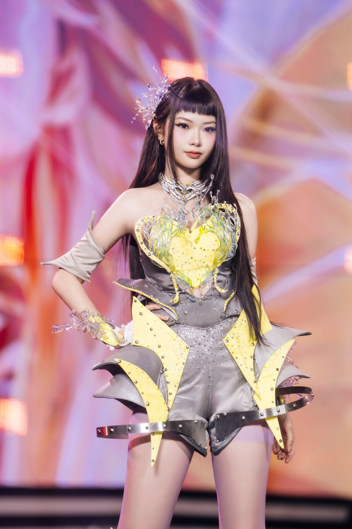 Lối trang điểm nhấn vào đôi mắt sắc nét cùng thần thái tự tin càng làm tăng sức hút, khiến Ánh Sáng AZA trông như một “chiến binh ánh sáng” đúng nghĩa khi đứng ở vị trí trung tâm.