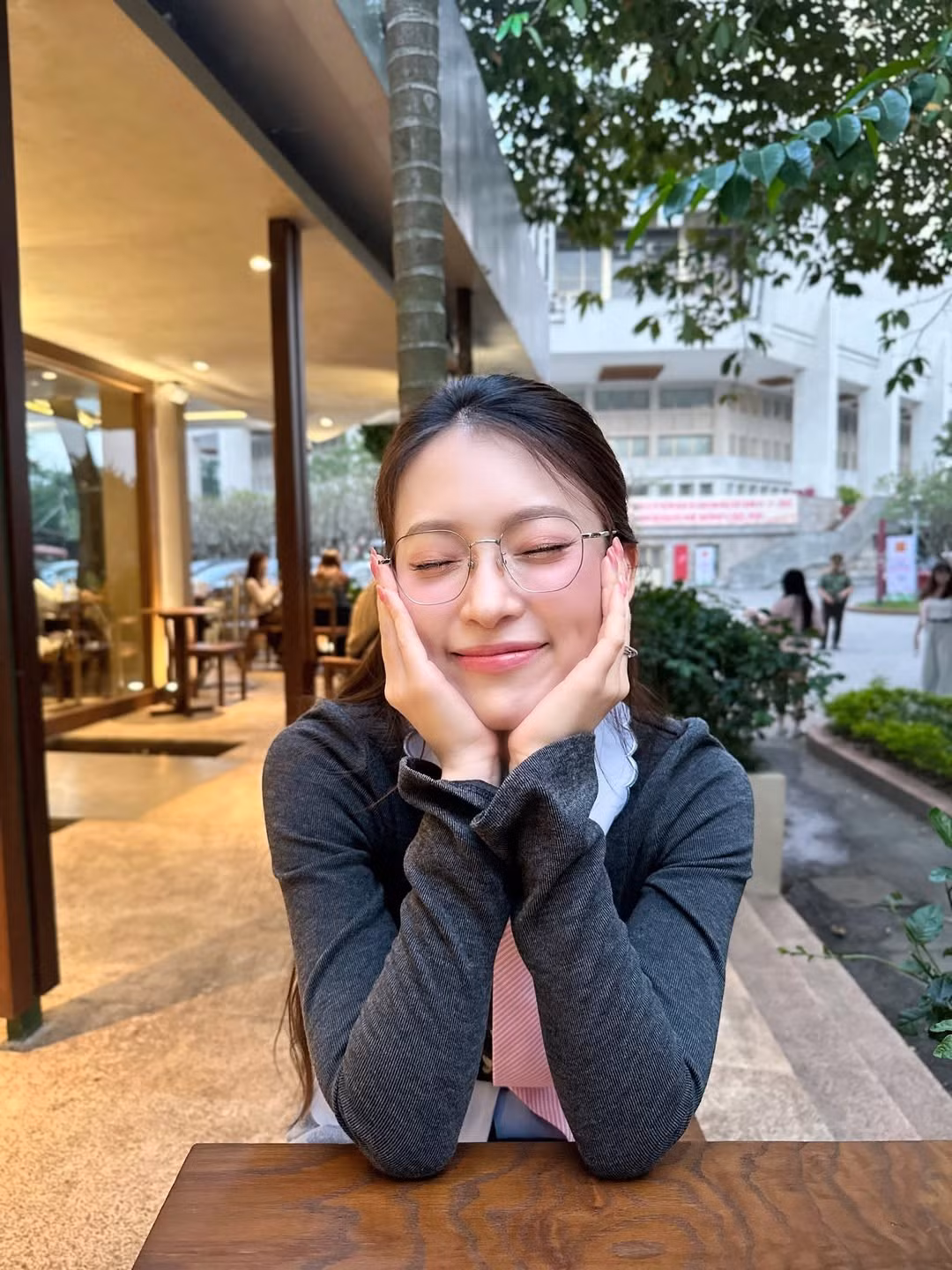 Vóc dáng của Khánh Vy nhỏ nhắn, thanh thoát. Cô đều thể hiện sự tự nhiên, thoải mái: khi ngồi trên ghế đá nâng ly đồ uống, khi mỉm cười nhìn thẳng camera, hay lúc quay lưng bước đi dưới những hàng đèn trang trí đỏ rực. Tất cả tạo nên vẻ đẹp trong trẻo, đời thường nhưng rất cuốn hút.