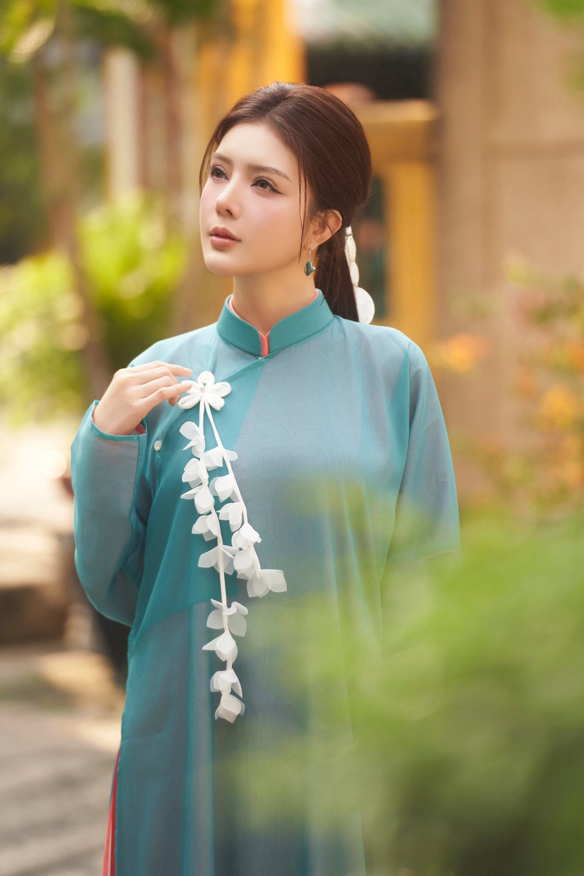 Không cần tạo dáng quá phức tạp, chỉ với những cử chỉ như khẽ nghiêng đầu, chạm tay vào đèn lồng hay ngồi thả lỏng trên ghế gỗ, người đẹp vẫn toát lên khí chất dịu dàng rất riêng.