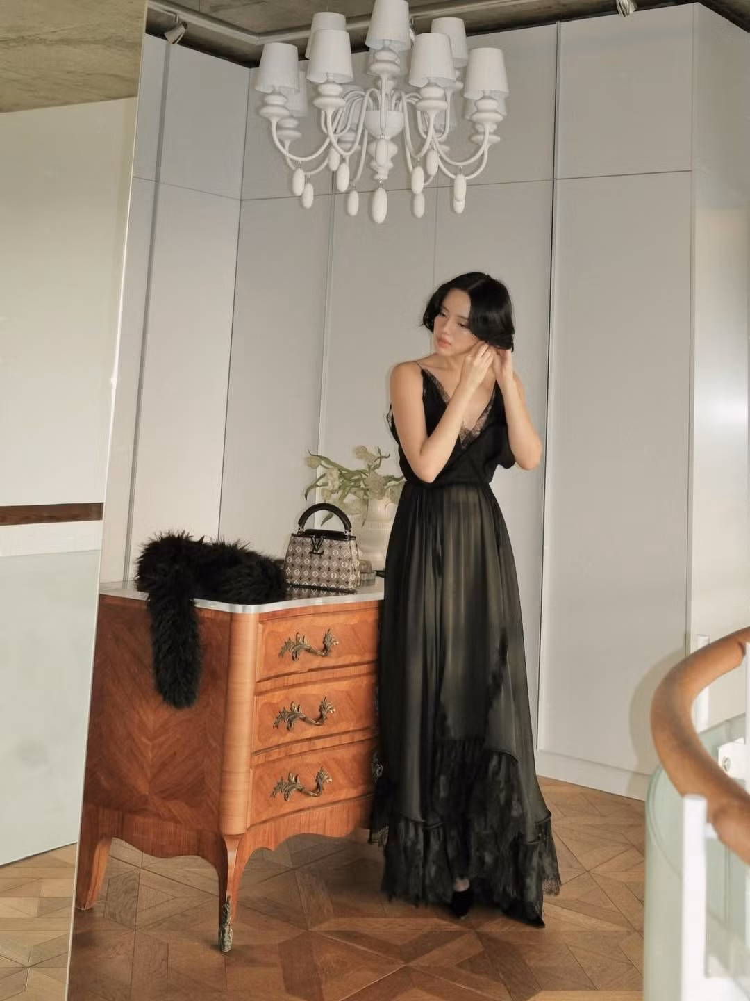 Gam màu đen kinh điển giúp tôn lên làn da trắng mịn, đồng thời làm nổi bật vóc dáng thon gọn, cân đối. Kiểu tóc ngắn uốn nhẹ ôm sát gương mặt mang hơi hướng cổ điển, kết hợp cùng lối trang điểm trong veo nhưng nhấn vào ánh mắt sâu và bờ môi hồng nude, tạo nên tổng thể vừa bí ẩn, vừa sang trọng.