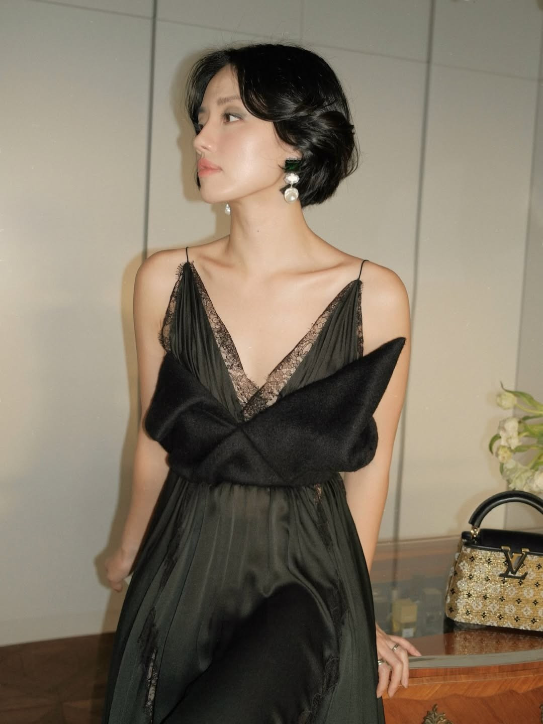 Trong bộ váy đen dáng dài với thiết kế hai dây mảnh, điểm nhấn ren tinh tế ở phần ngực, Khánh Linh khéo léo khoe bờ vai thanh mảnh và xương quai xanh gợi cảm.