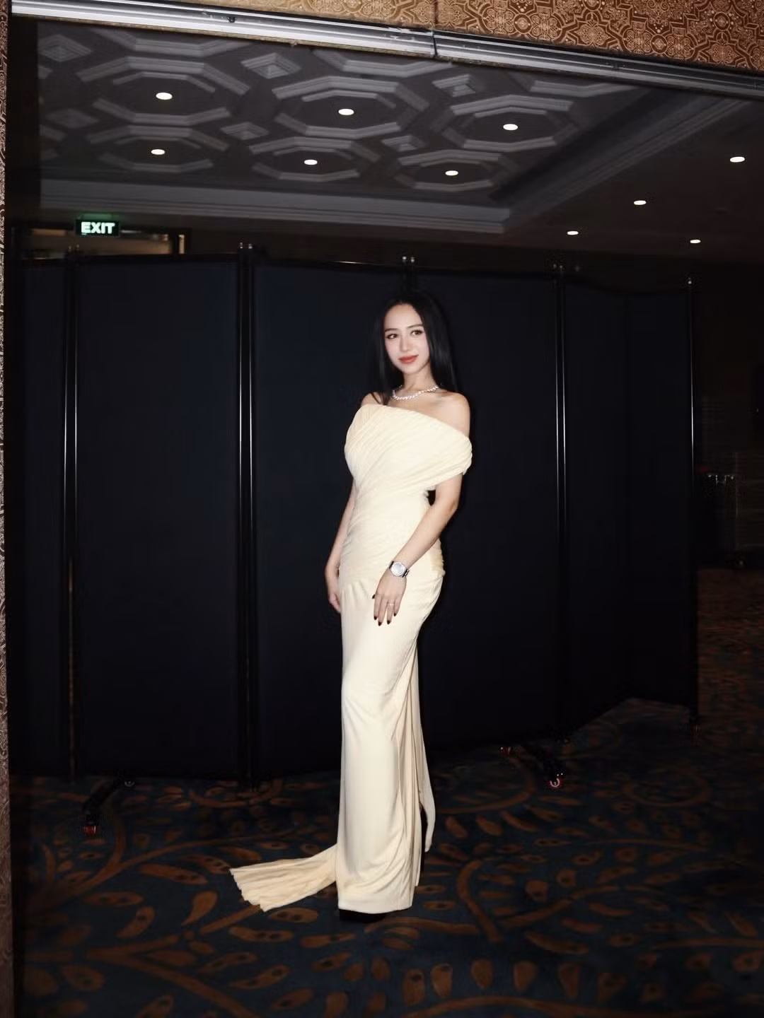 Xuất hiện trong loạt hình mới, Joyce Phạm (Phạm Trần Nguyễn Minh Anh) gây chú ý mạnh mẽ khi diện một thiết kế đầm dài màu kem với phom dáng ôm sát, tôn trọn đường cong mềm mại. Bộ váy trễ vai với những nếp drap tinh tế giúp cô nàng toát lên vẻ đẹp thanh lịch nhưng vẫn quyến rũ, gợi cảm vừa đủ.