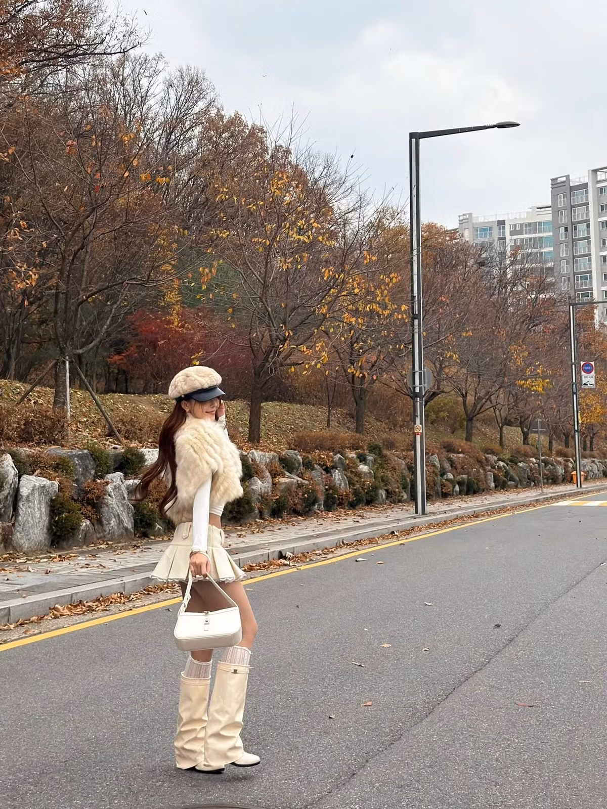 Trong loạt ảnh được ghi lại, Hà Môi xuất hiện giữa những tán lá phong đỏ rực, khoe trọn nét đẹp nữ tính, thanh thoát. Cô chọn tông trang phục kem – trắng làm chủ đạo, tạo nên sự hài hòa với phông nền mùa thu.