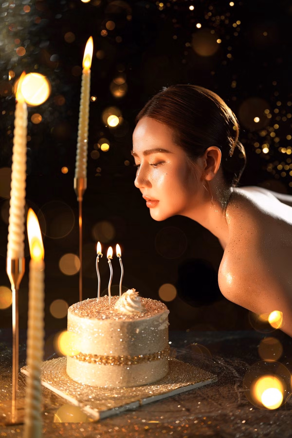 Cô nàng diện chiếc váy quây màu đen quyến rũ, khoe đôi vai trần được nhấn bằng nhũ vàng tôn lên vẻ huyền bí và lấp lánh.