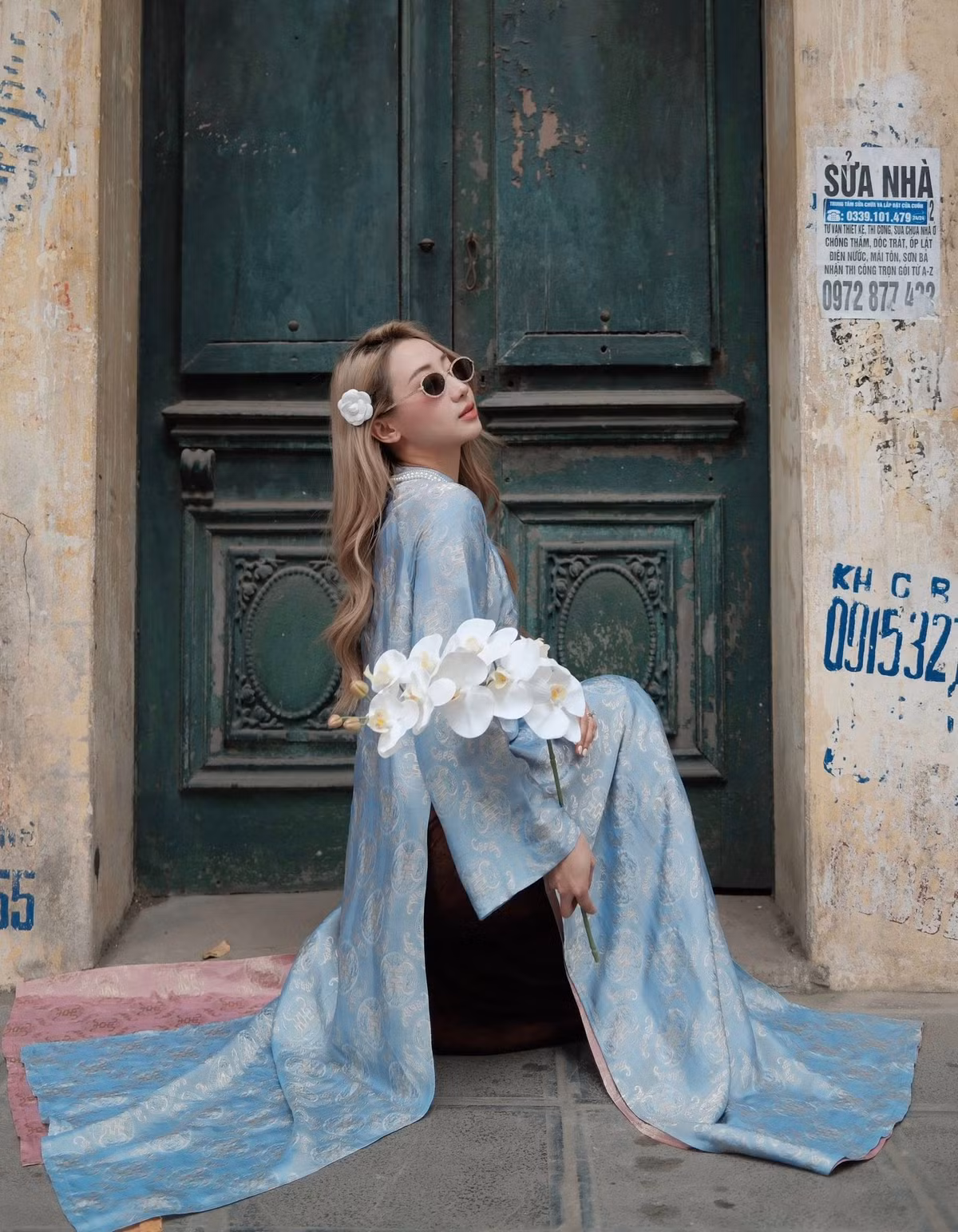 Bối cảnh chụp hình cũng góp phần quan trọng làm nổi bật thần thái của người đẹp Hà thành. Không gian phủ sắc đỏ của những lớp vải lụa buông rủ tạo chiều sâu thị giác, mang hơi thở sân khấu nghệ thuật pha chút hoài cổ.