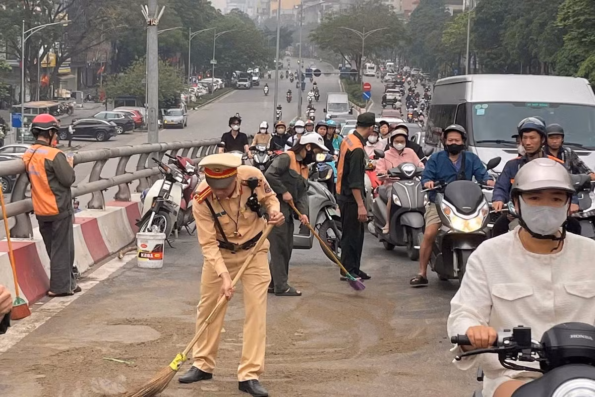 Cảnh sát và nhân viên Ban quản lý cầu dùng cát khô khắc phục sự cố.