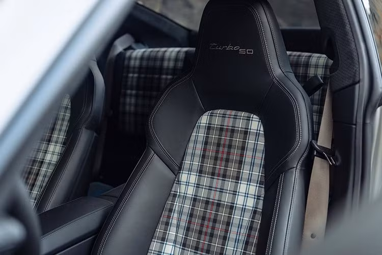 Bảng táp-lô phía hành khách được khắc số thứ tự sản xuất trong tổng 1.974 xe, kèm huy hiệu “Turbo 50”. Xe còn được trang bị gói Sport Chrono, bao gồm các chức năng như Launch Control, đồng hồ analogue đo vòng đua, cần số thiết kế lấy cảm hứng từ xe đua, và chế độ lái tích hợp vô lăng.
