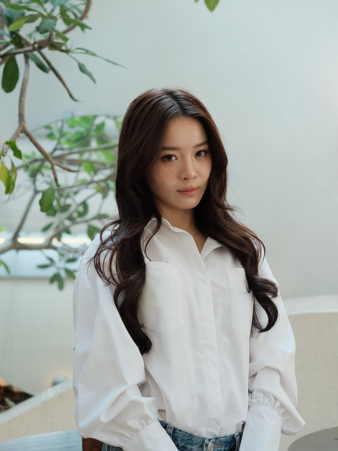 Lối trang điểm nhẹ nhàng, tập trung vào làn da căng bóng và đường nét tự nhiên giúp Karen Nguyễn giữ trọn tinh thần thanh lịch của áo sơ mi trắng.