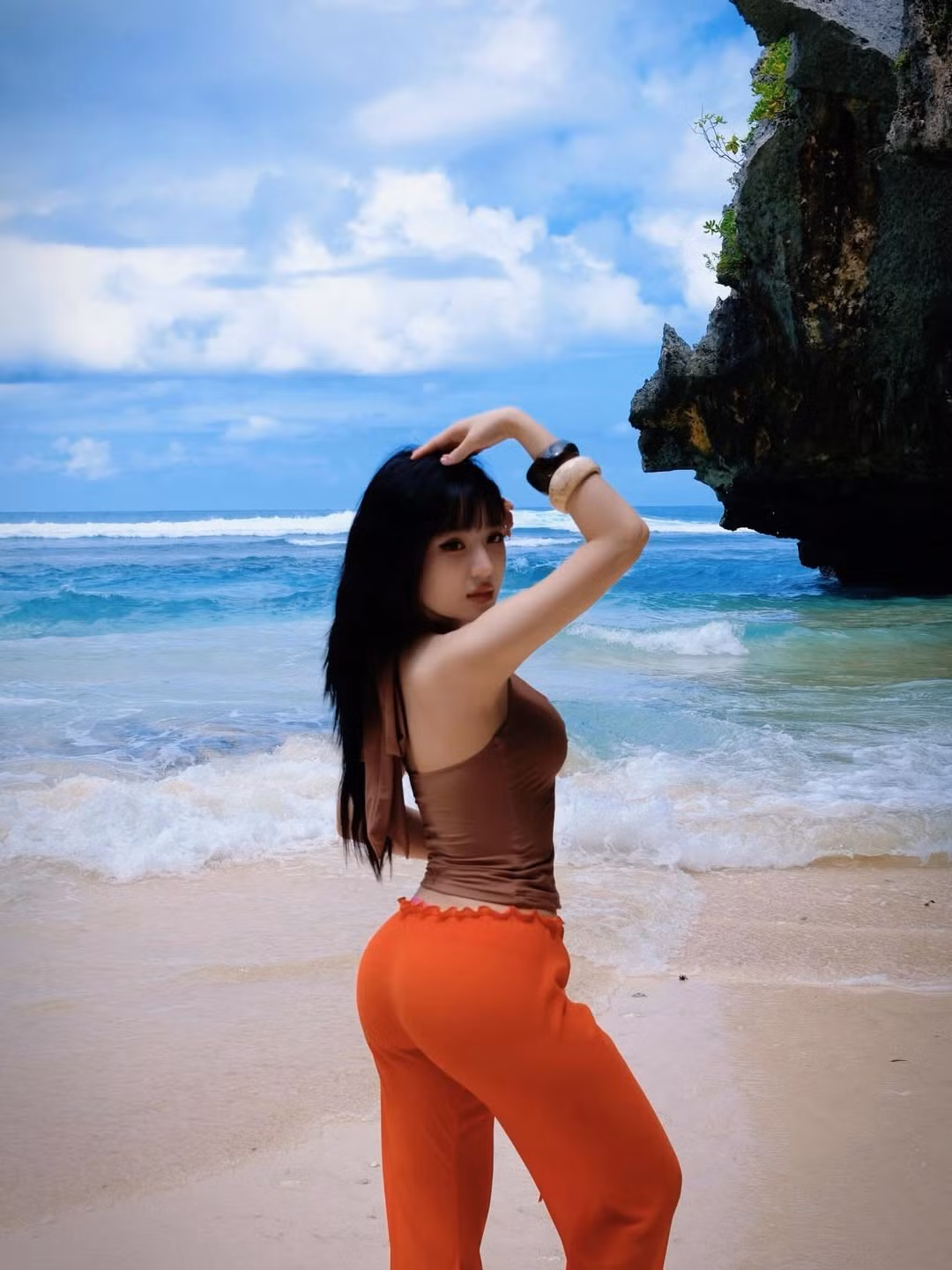 Người đẹp diện bộ trang phục tông nâu – cam nổi bật, giúp tôn lên vóc dáng thon gọn và vòng eo săn chắc.