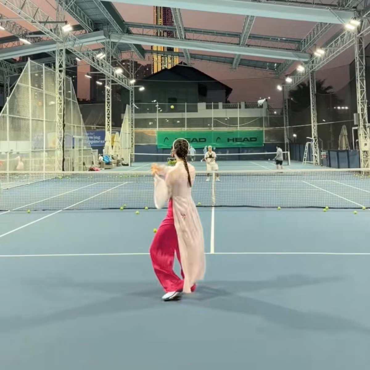 Trong loạt hình ảnh được chia sẻ, Lương Thùy Linh diện áo dài gam màu nhã nhặn, phom dáng truyền thống, kết hợp cùng giày thể thao và phụ kiện tối giản. Sự kết hợp tưởng chừng “lệch pha” này lại tạo nên tổng thể hài hòa, vừa giữ được nét duyên dáng của áo dài, vừa phù hợp với tinh thần năng động của bộ môn tennis. Hình ảnh nàng hậu tự tin cầm vợt, nở nụ cười rạng rỡ trên sân khiến nhiều người không khỏi bất ngờ và thích thú.