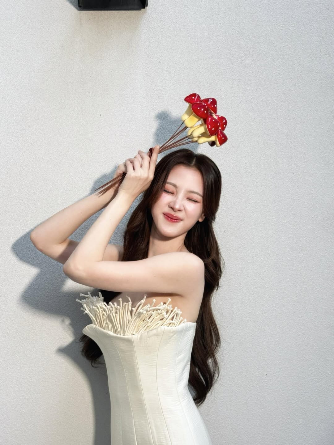 Mái tóc nâu sẫm uốn lơi buông dài càng làm tôn lên vẻ dịu dàng, nữ tính, trong khi nụ cười rạng rỡ và thần thái tự tin lại mang đến sức hút rất riêng, vừa ngọt ngào vừa hiện đại.